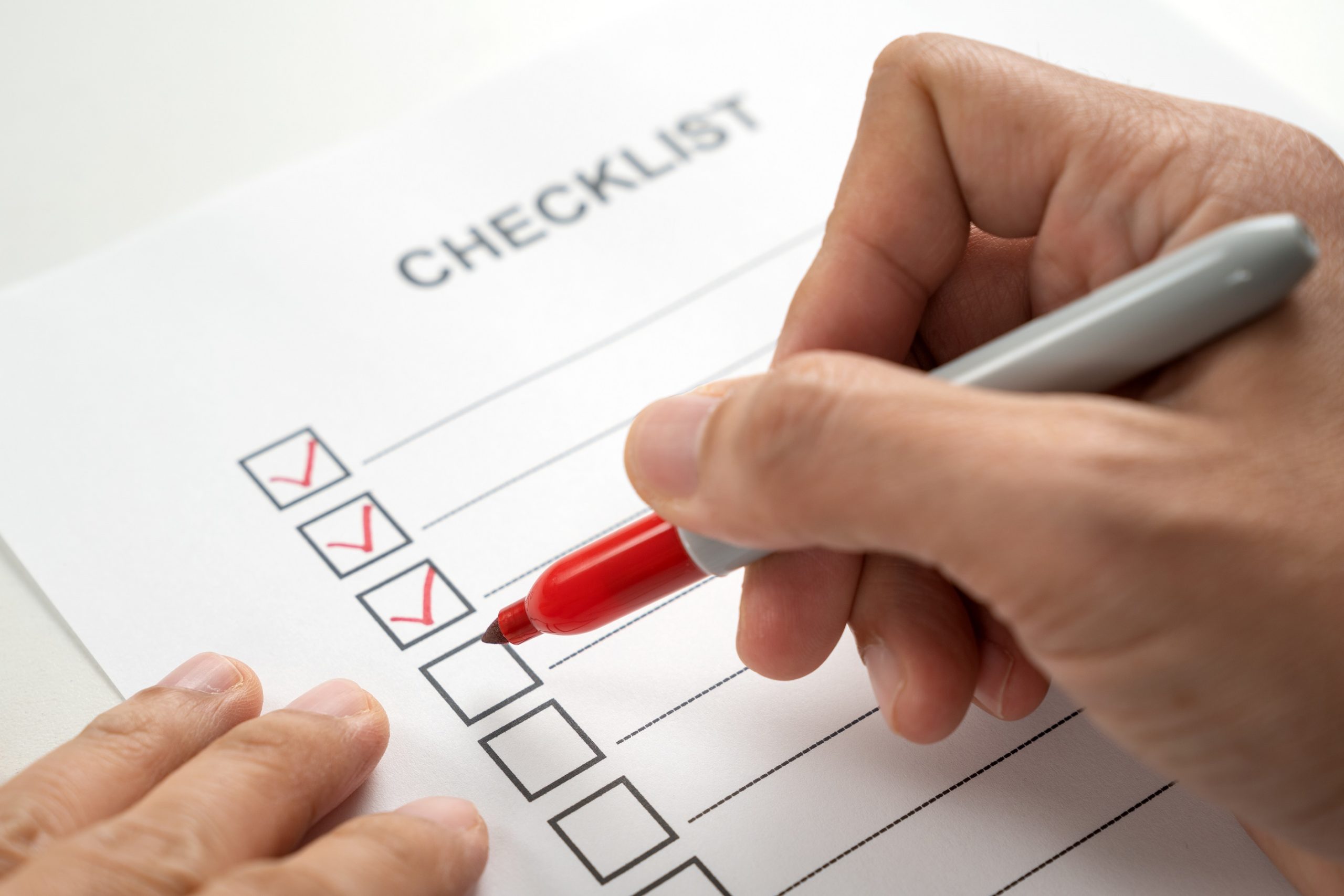 Hand with red marker pen marking on checklist box Person writing the visitor management system features