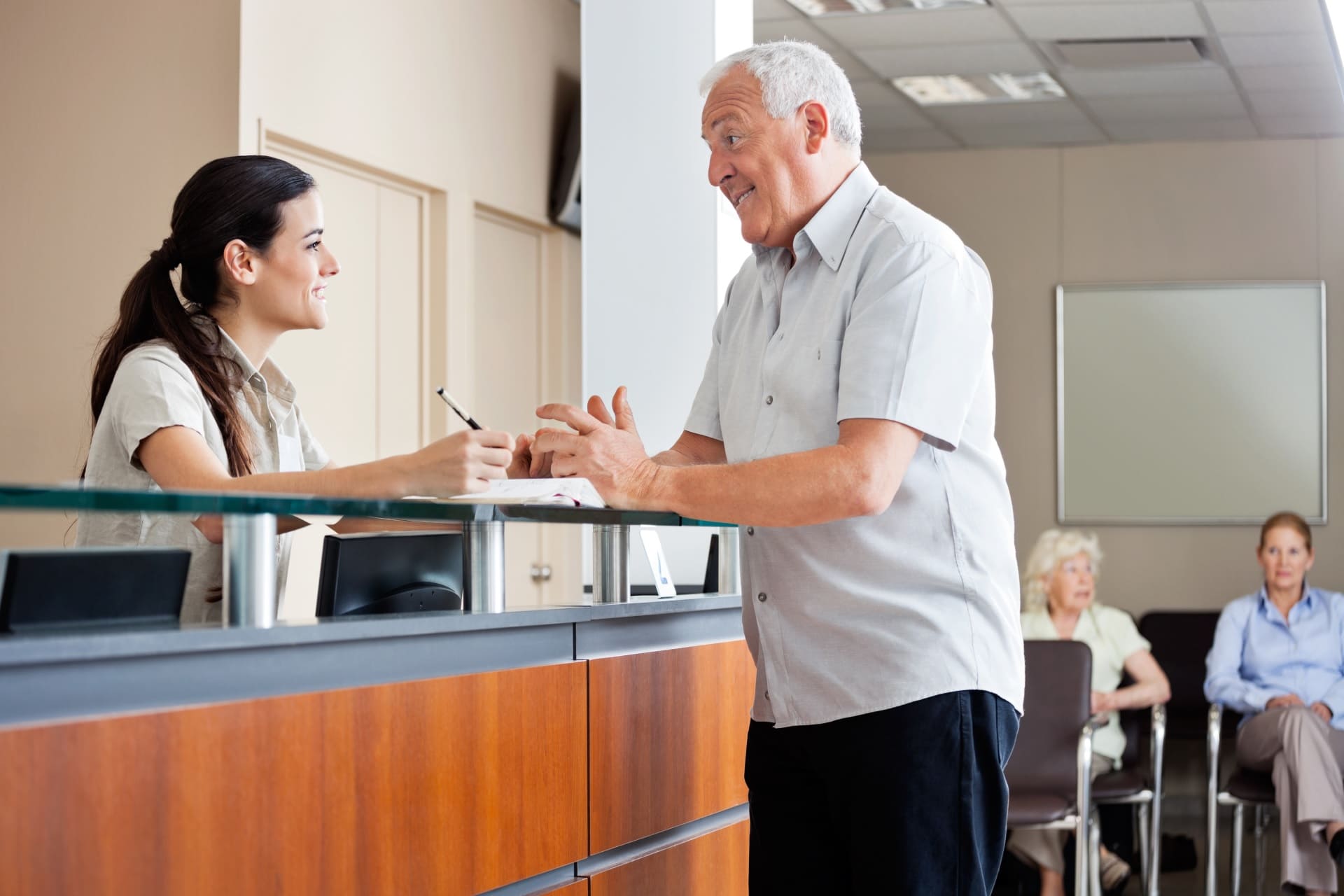 receptionist-facilitating-patient-experience-with-happy-patient Receptionist facilitating patient experience with happy patient