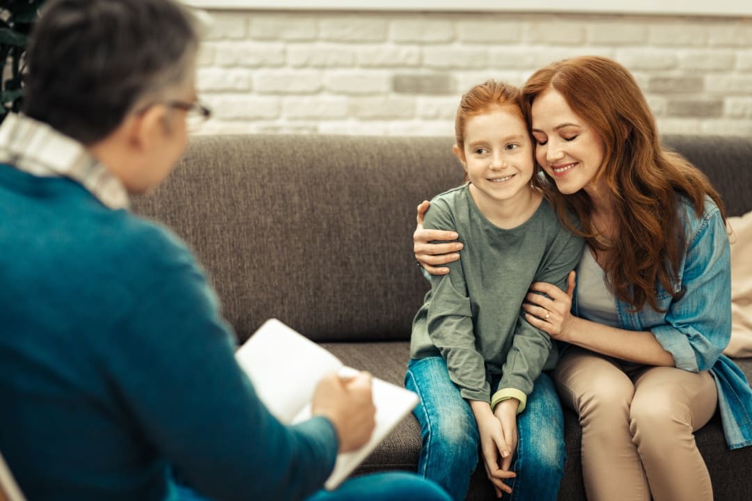 therapist-facilitating-positive-patient-experience-with-child-and-parent Therapist facilitating positive patient experience with child and parent